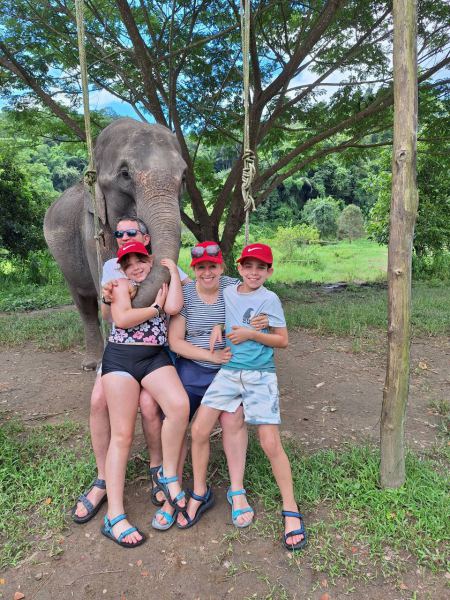 Family photo with an elephant reaching down to them - lifeonwheel.com