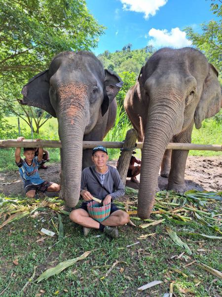 Father and son feeding two elephants together - lifeonwheel.com