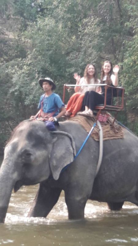 Two guests riding an elephant through the river - lifeonwheel.com
