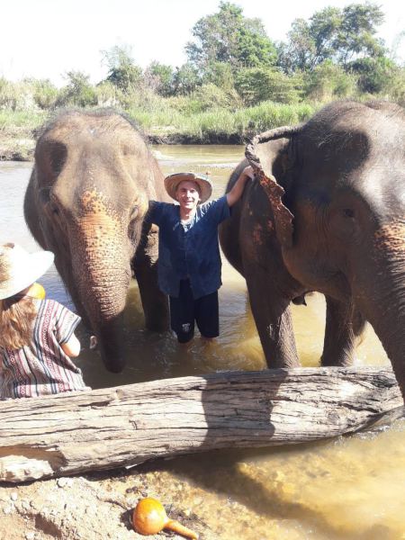 Standing between two elephants in the shallow river - lifeonwheel.com