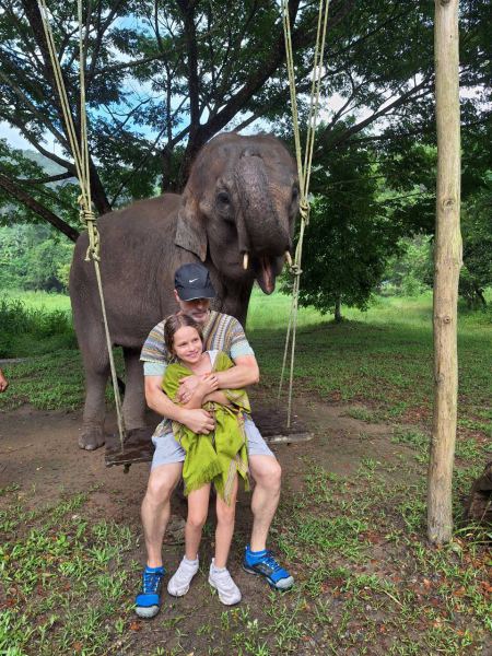 A couple on the elephant swing beneath the trees - lifeonwheel.com