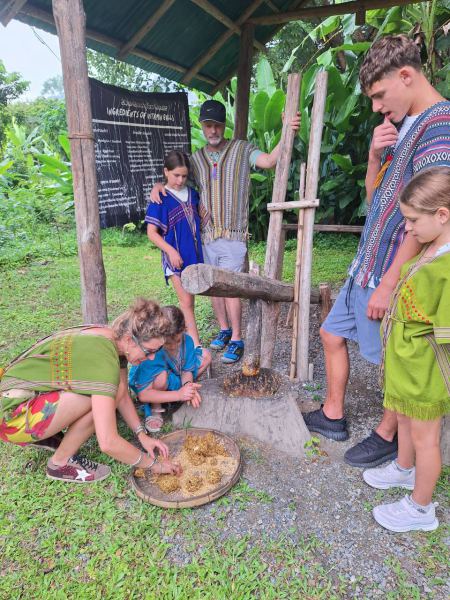 A family in traditional dress watching the medicine pounding - lifeonwheel.com