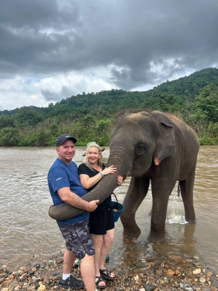 A couple guiding a young elephant by the trunk - lifeonwheel.com