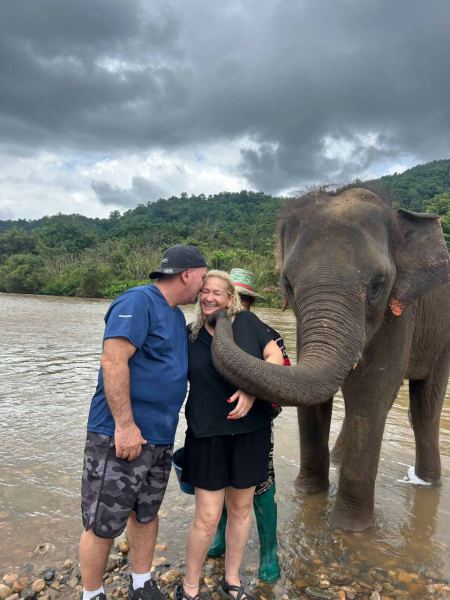 A tender embrace with a guest and an elephant by the river - lifeonwheel.com