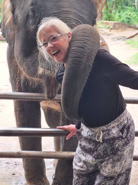 An elephant resting its trunk on a guest's shoulder affectionately - lifeonwheel.com