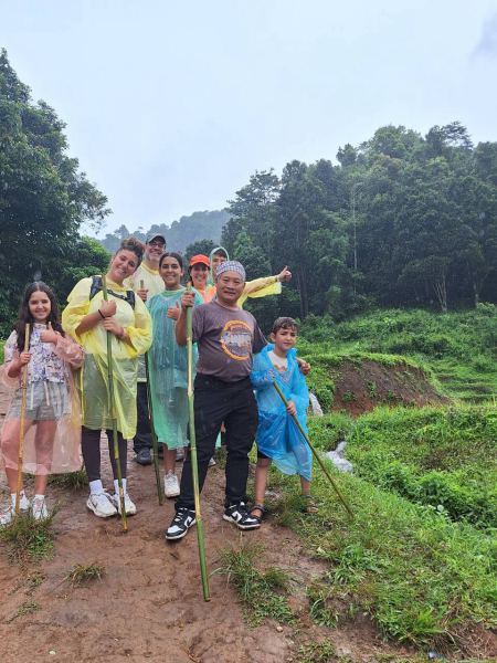 A group of trekkers with walking sticks posing on a misty trail - lifeonwheel.com