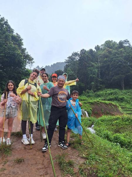 Trekkers in colorful ponchos posing together beside rice terraces - lifeonwheel.com