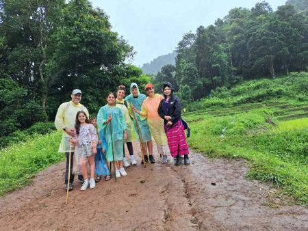 The group posing on a muddy road with rice terraces beside the trail - lifeonwheel.com