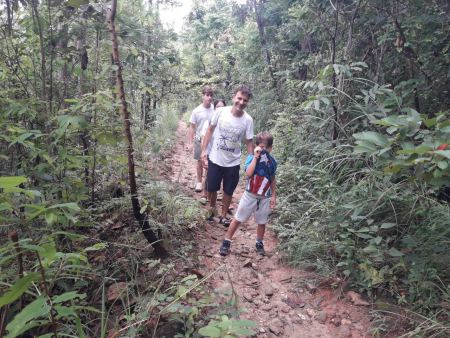 Trekkers walking a forest trail with a boy in a backpack - lifeonwheel.com