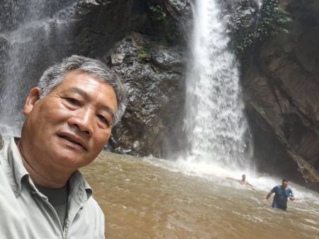 Our guide beside the powerful waterfall with swimmers below - lifeonwheel.com