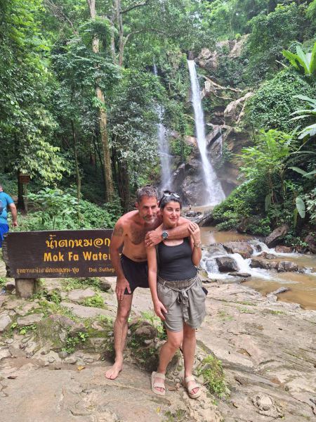 A couple at the Mok Fa Waterfall sign - lifeonwheel.com