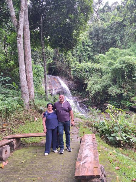 A couple on the benches by the forest waterfall - lifeonwheel.com
